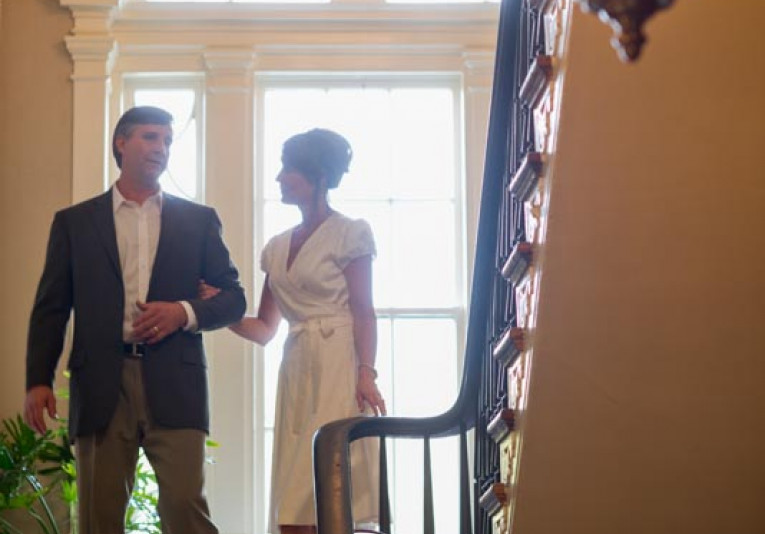 man and woman walking in an entrance holding hands.