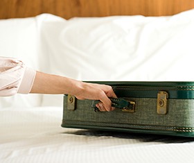woman holding a briefcase on top of a bed